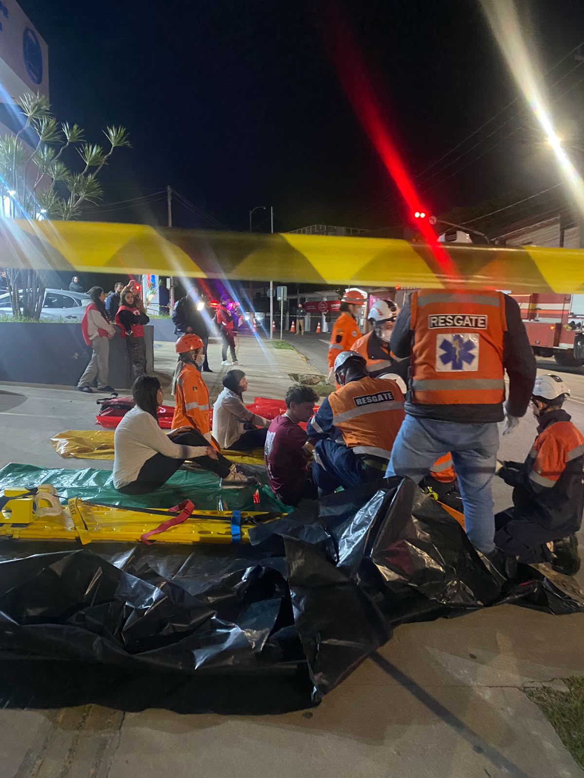 Cena do simulado de emergência realizado por alunos da QI, com vítimas e resgate delimitados pela fita de segurança
