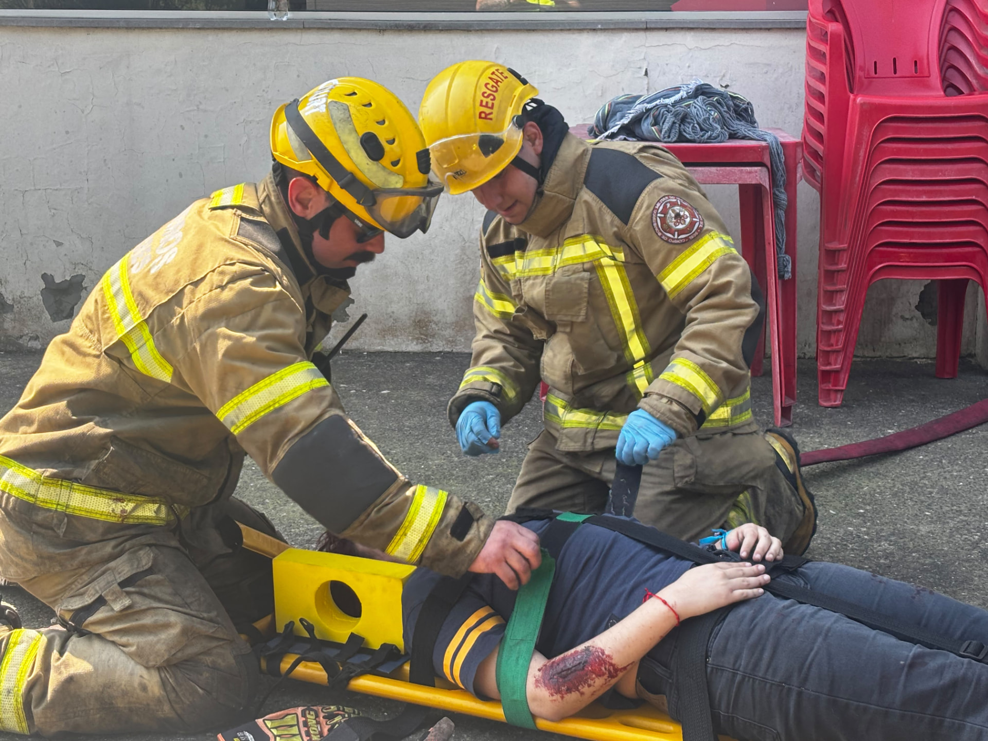 Aluno do Técnico em Segurança do Trabalho da QI, com capacete amarelo, realiza o atendimento a uma vítima durante o simulado de emergência