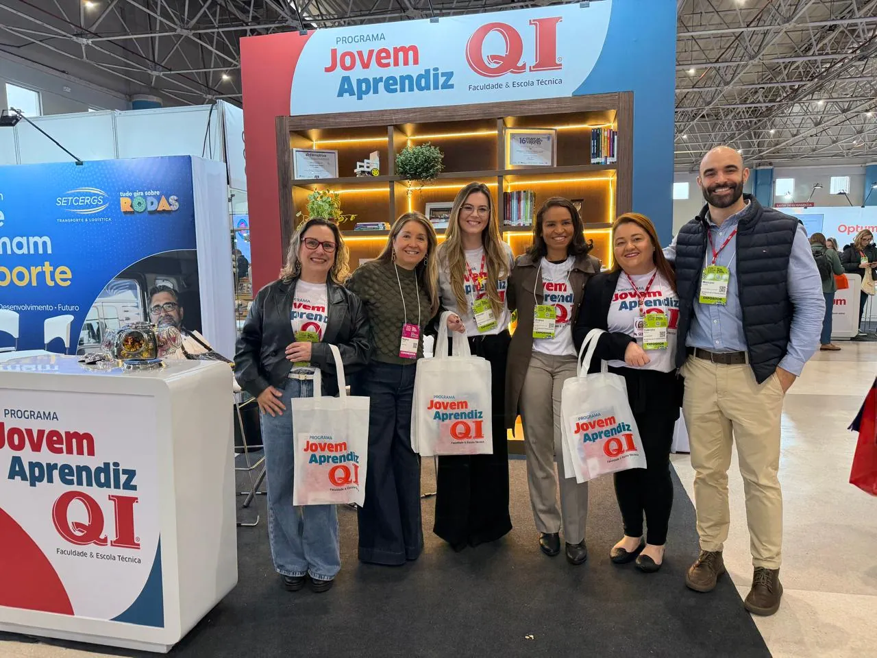 Grupo com sacolas personalizadas no estande da QI no CONGREGARH 2026