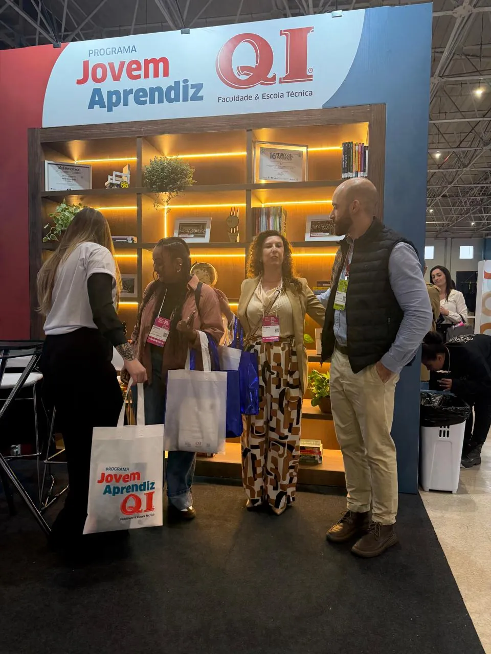 Grupo de pessoas no estande do Jovem Aprendiz QI no CONGREGARH 2026